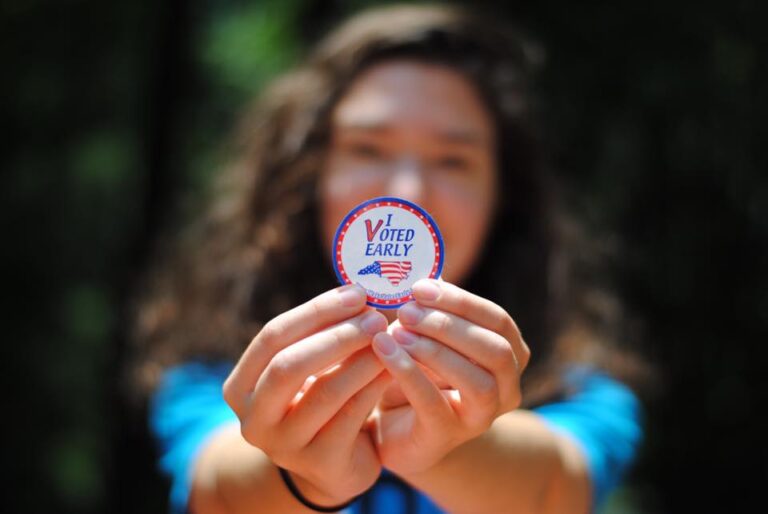 Wmoan holding a I Voted Eary sticker.