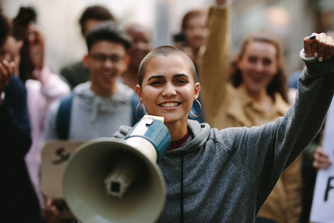 img - woman smiling leads crowd with megaphone woman smiling leads crowd with megaphone